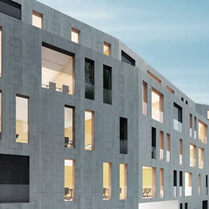 Sustainable office building with a geometric concrete facade and warm interior lighting.