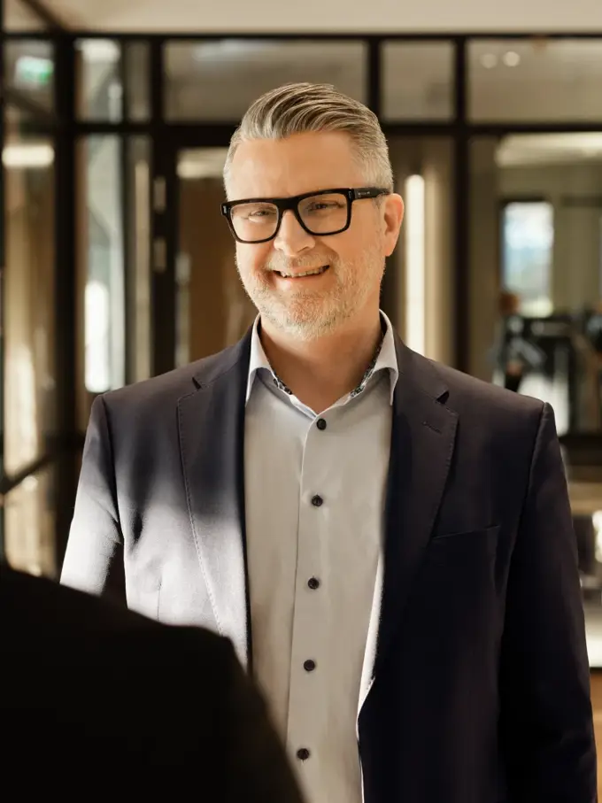 Man smiling during a conversation in a hallway of a B2B energy solutions company.